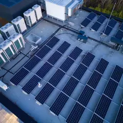 Panele słoneczne i jednostki klimatyzacyjne na dachu. Systemy te, choć różne, współpracują, minimalizując reaktancję i optymalizując zużycie energii.