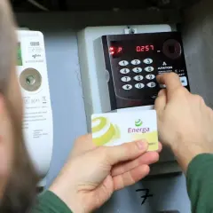 Doładowanie licznika PGE w weekend. Karta Energa w dłoni, wprowadzanie kodu na klawiaturze licznika.