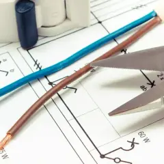 Schemat elektryczny, nożyczki i przewody. Czy czerwony to plus czy minus? Zależy od kontekstu instalacji.
