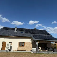 Dom z panelami fotowoltaicznymi na dachu. Zastanawiasz się, ile kosztuje fotowoltaika? To inwestycja w przyszłość i oszczędności.