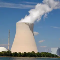 Chłodnia kominowa i budynki elektrowni atomowych w Niemczech na tle błękitnego nieba.