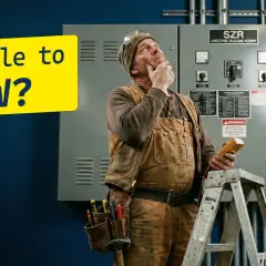 Elektryk zastanawia się nad mocą pozorną, trzymając miernik. Żółty napis pyta: "kVA ile to KW?".