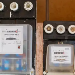 Dwa liczniki energii elektrycznej, jeden z czerwonym wskaźnikiem awarii. Uważaj na oszustów przy wymianie licznika Tauron.