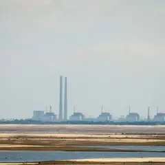 Widok na elektrownię Zaporoże z chłodnią kominową i kilkoma blokami energetycznymi na tle nieba.