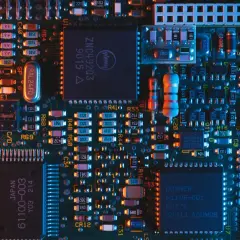 Płytka drukowana z licznymi elementami elektronicznymi, w tym układami scalonymi i rezystorami. Wśród nich można dostrzec oznaczenia sugerujące zastosowanie technologii chłodzenia, jak ogniwo Peltiera.