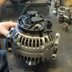Warsztat samochodowy, gdzie mechanik sprawdza alternator. Dowiedz się, ile kosztuje regeneracja alternatora i jakie części są potrzebne.