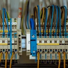 Zaciski przyłącza elektrycznego z kolorowymi przewodami, uporządkowane i oznaczone numerami.