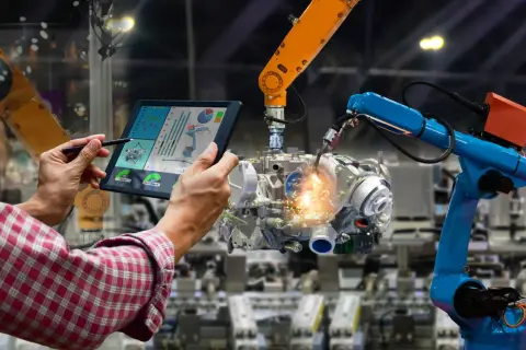 Operator kontroluje pracę robotów spawalniczych na tablecie, optymalizując procesy dla większych automatyk zarobki.