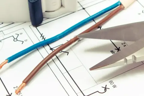 Schemat elektryczny, nożyczki i przewody. Czy czerwony to plus czy minus? Zależy od kontekstu instalacji.