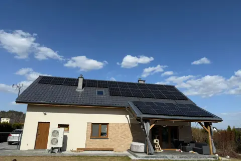 Dom z panelami fotowoltaicznymi na dachu. Zastanawiasz się, ile kosztuje fotowoltaika? To inwestycja w przyszłość i oszczędności.