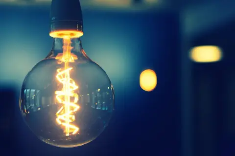 Żarówka z widocznym żarnikiem, symbolizująca energię i potencjalnie taryfę g11.
