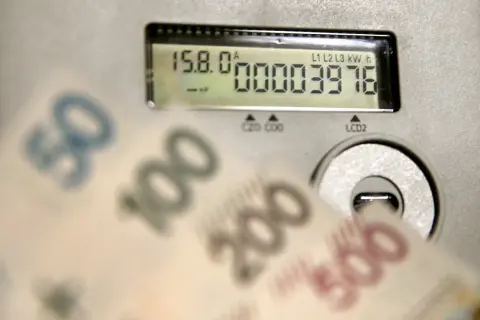 Liczniki energii i banknoty symbolizują koszty, w tym opłatę kogeneracyjną.