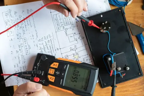 Pomiar rezystancji izolacji. Multimetr pokazuje 0.855 V, a ręka trzyma sondę do pomiaru.