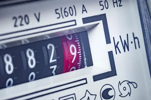 Zbliżenie na licznik energii elektrycznej, pokazujący aktualne zużycie prądu. Widoczne cyfry 8829 i oznaczenie kWh.