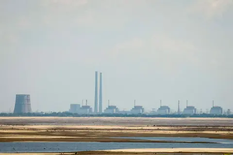 Widok na elektrownię Zaporoże z chłodnią kominową i kilkoma blokami energetycznymi na tle nieba.