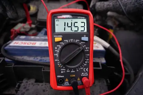 Multimetr pokazuje 14.53V, co jest kluczowe, jak sprawdzić regulator napięcia w samochodzie.