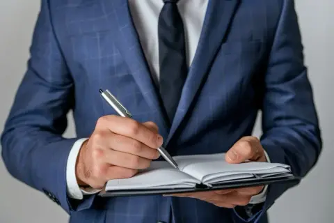 Biznesmen w garniturze notuje ważne informacje. Czy to będą pozytywne axpo polska opinie?
