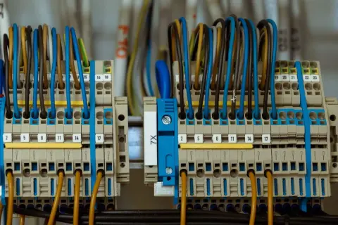 Zaciski przyłącza elektrycznego z kolorowymi przewodami, uporządkowane i oznaczone numerami.