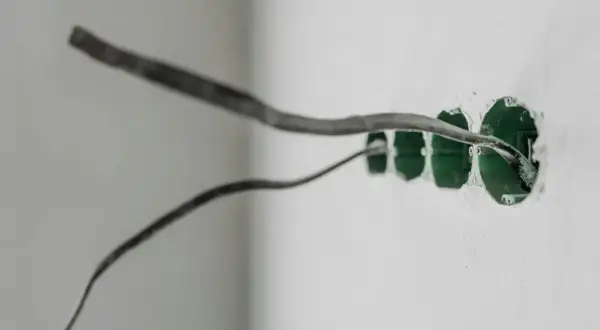 Przewody elektryczne wchodzące do puszek instalacyjnych. Widać przygotowania do montażu gniazdek, kluczowe dla prawidłowego uziemienia w gniazdku.
