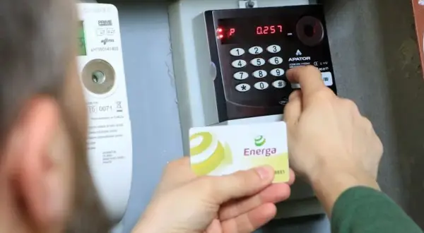 Doładowanie licznika PGE w weekend. Karta Energa w dłoni, wprowadzanie kodu na klawiaturze licznika.