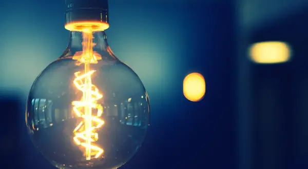 Żarówka z widocznym żarnikiem, symbolizująca energię i potencjalnie taryfę g11.