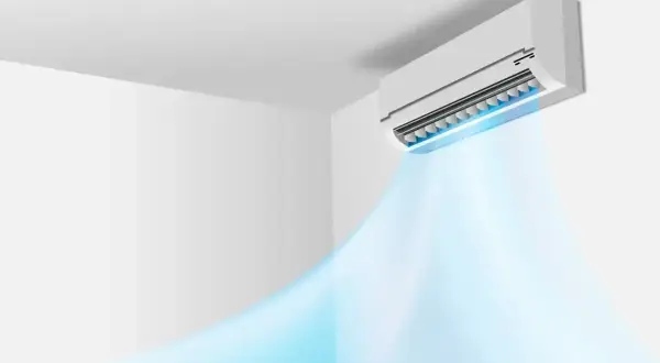 Klimatyzator ścienny emituje chłodne, niebieskie powietrze w pomieszczeniu.