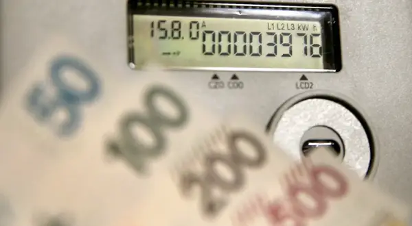 Liczniki energii i banknoty symbolizują koszty, w tym opłatę kogeneracyjną.