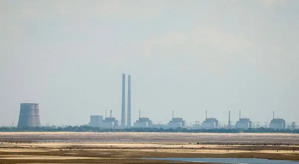 Widok na elektrownię Zaporoże z chłodnią kominową i kilkoma blokami energetycznymi na tle nieba.