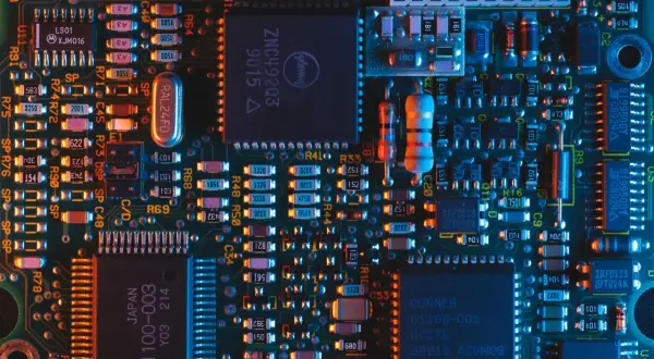 Płytka drukowana z licznymi elementami elektronicznymi, w tym układami scalonymi i rezystorami. Wśród nich można dostrzec oznaczenia sugerujące zastosowanie technologii chłodzenia, jak ogniwo Peltiera.