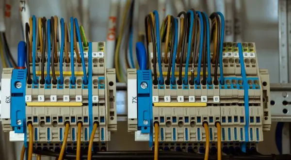 Zaciski przyłącza elektrycznego z kolorowymi przewodami, uporządkowane i oznaczone numerami.