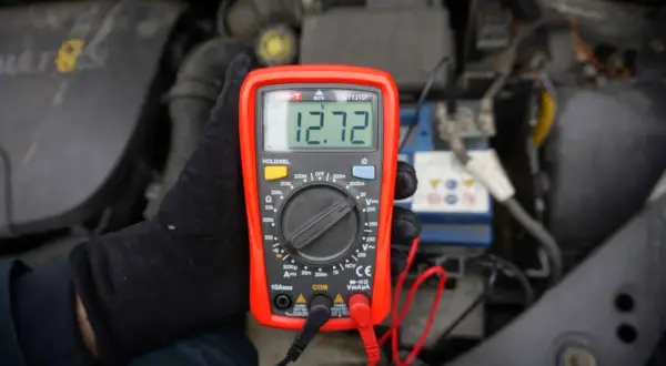 Sprawdzanie akumulatora miernikiem. Wynik 12.72V pokazuje, że jest w dobrym stanie.