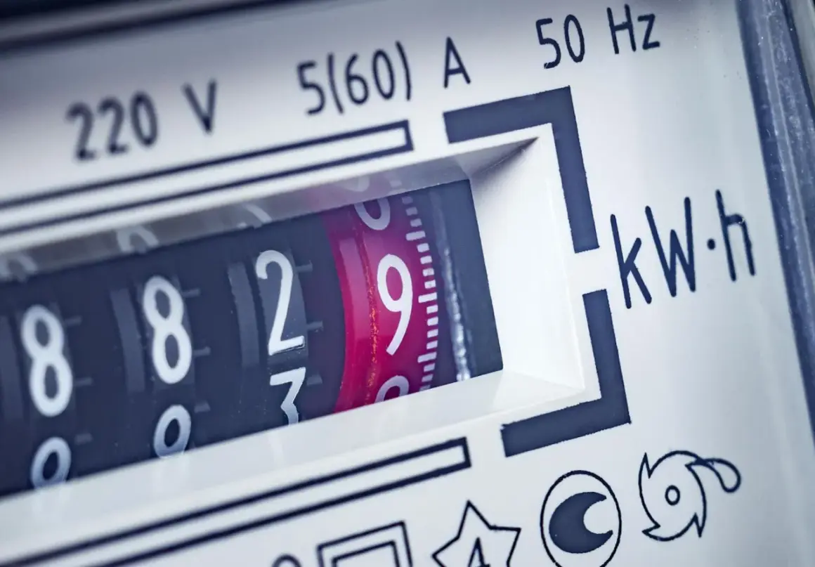 Zbliżenie na licznik energii elektrycznej, pokazujący aktualne zużycie prądu. Widoczne cyfry 8829 i oznaczenie kWh.