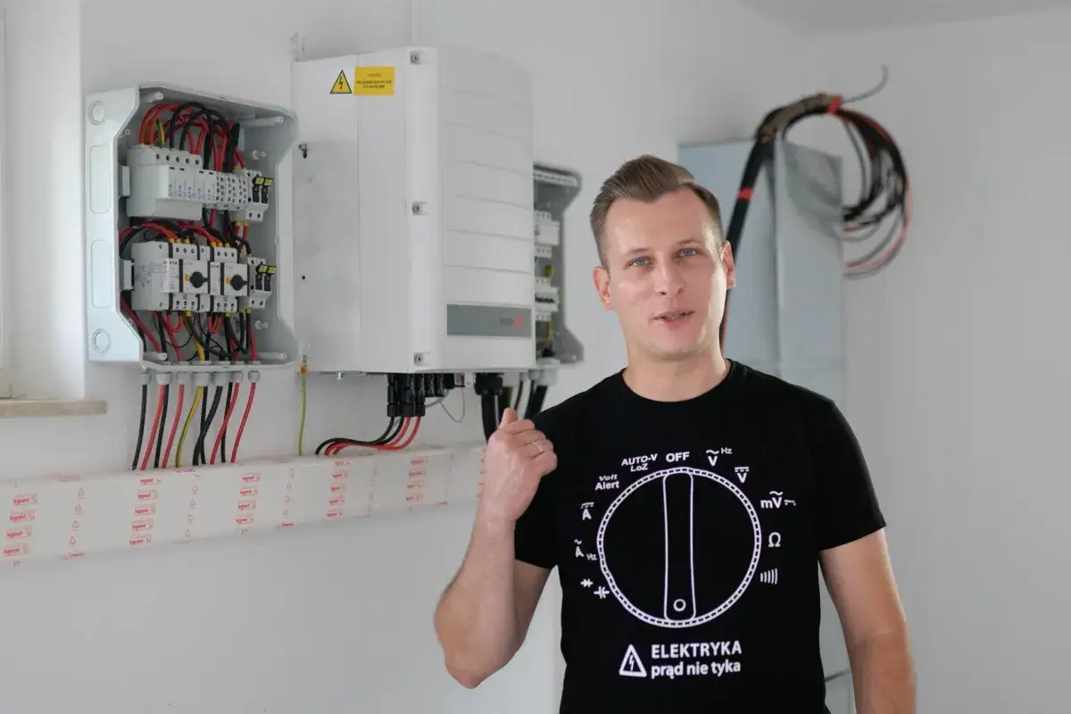 Elektryk z uprawnieniami SEP do 1kV prezentuje instalację fotowoltaiczną.