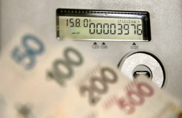 Liczniki energii i banknoty symbolizują koszty, w tym opłatę kogeneracyjną.