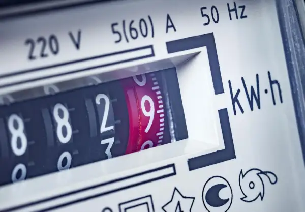 Zbliżenie na licznik energii elektrycznej, pokazujący aktualne zużycie prądu. Widoczne cyfry 8829 i oznaczenie kWh.