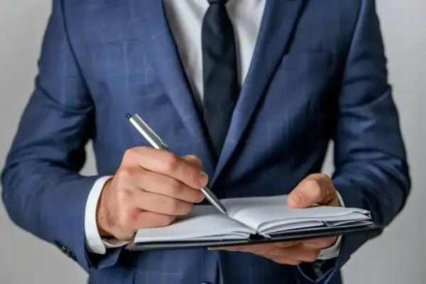 Biznesmen w garniturze notuje ważne informacje. Czy to będą pozytywne axpo polska opinie?