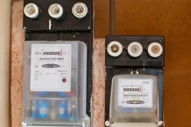 Dwa liczniki energii elektrycznej, jeden z czerwonym wskaźnikiem awarii. Uważaj na oszustów przy wymianie licznika Tauron.